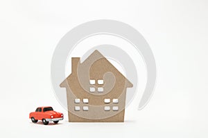 Miniature house and car on white background.