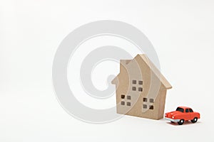 Miniature house and car on white background.