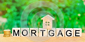 Miniature house and dollars. Wooden blocks and the inscription `mortgage`. credit for property / apartment. Business loans for rea