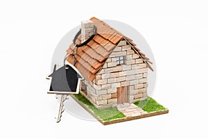 Miniature house with a key hooked in the chimney
