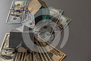 Miniature house model with banknotes on a wooden table, selective focus. Home loan concept.