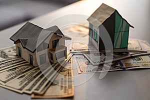 Miniature house model with banknotes on a wooden table, selective focus. Home loan concept.