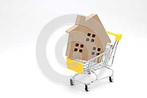 Shopping cart and house on white background. Concept of buying new house, real estate and home mortgage.