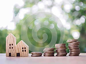 Miniature house and stack of coins. The concept of saving money for house, Property investment, House mortgage, Real estste
