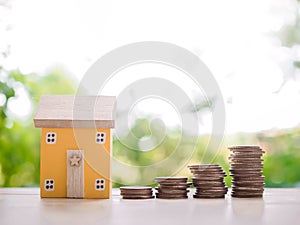 Miniature house and stack of coins. The concept of saving money for house, Property investment, House mortgage, Real estste
