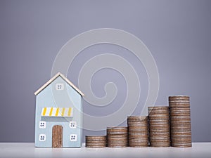 Miniature house and stack of coins. The concept of saving money for house, Property investment, House mortgage, Real estste