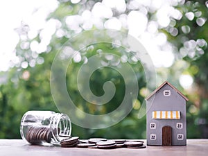 Miniature house and stack of coins. The concept of saving money for house, Property investment, House mortgage, Real estste