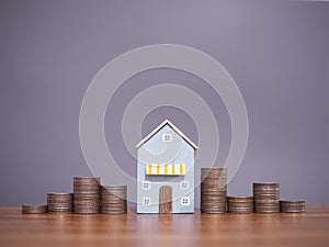 Miniature house and stack of coins. The concept of saving money for house, Property investment, House mortgage, Real estste