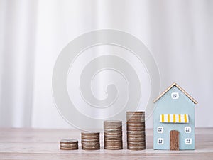 Miniature house and stack of coins. The concept of saving money for house, Property investment, House mortgage, Real estste