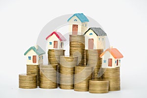 Miniature house on stack coins using as property and business concep, isolated on white background