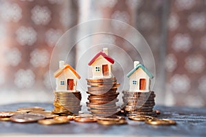 Miniature house on stack coins using as property real estate and financial concept