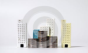 Miniature houses and piles of coins.