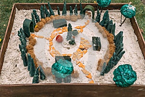 Miniature houses, toy landscape objects in sandbox. Anti-stress and soothing sand therapy.
