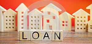 Miniature houses with the word Loan. The concept of mortgage housing and real estate loans. Buy an apartment on credit. Leasing.