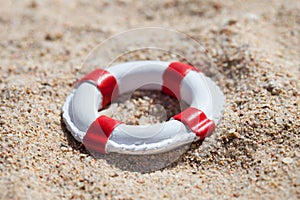 Miniature lifebuoy on sand