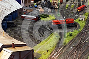 A miniature locomotive depot with railroad tracks, locomotives and buildings..