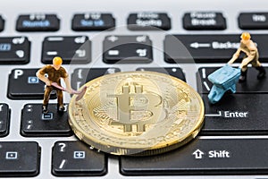 Miniature man are digging Mining Golden bitcoins.