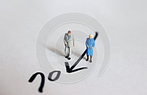 A miniature man and a miniature woman walking towards the Number 70.