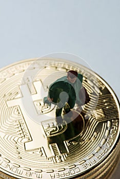 Miniature man on a pile of bitcoins