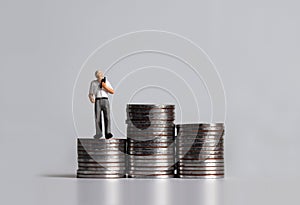 A miniature man on the piles of coins.