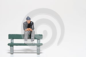 Miniature of a man sitting on a bench