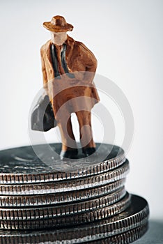 Miniature man with a suitcase on dollar coins
