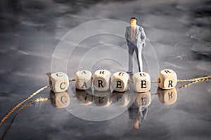 Miniature model of businessmen and wooden cubes with career inscription strung on a thread