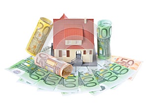 Miniature model of houses on stacked euro banknotes, on isolated white background. Real estate investment concept. Saving money fo