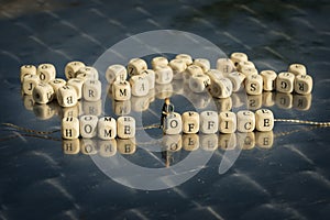 Miniature model of people and wooden cubes with home office inscription strung on a thread