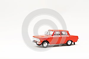 Miniature model of a red retro car on a white background