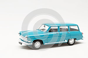 Miniature model of a toy blue retro car on a white background.