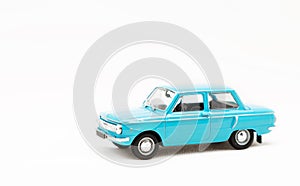 Miniature model of a toy blue retro car on a white background.