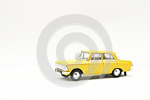 Miniature model of a yellow retro car on a white background
