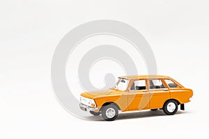 Miniature model of a yellow retro car on a white background