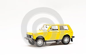 Miniature model of a yellow retro car on a white background