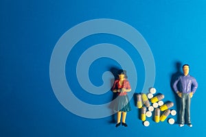 Miniature models and Pills, drugs on blue background. Healthcare concept