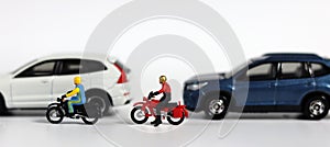 Miniature motorcycle messenger between miniature cars.