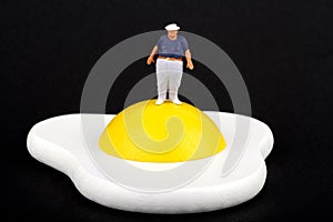 Miniature of an obese man and fried egg