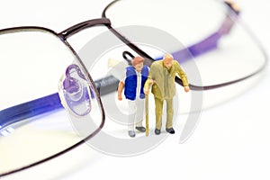 Miniature old couple and optical glasses. Senior age couple walking with support.