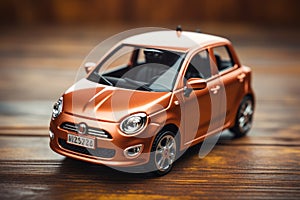 Miniature orange toy car model displayed on wooden tabletop surface for collectors or decor photo