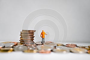 Miniature peaople, technician standing with stack coins
