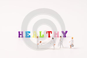 Miniature peaple healthy teamwork with HEALTHY text photo