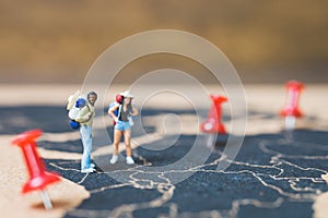 Miniature people backpacker walking on world map