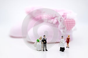 Miniature people : Bride and groom wear wedding suit and waiting for baby in the future . Image use for make new family