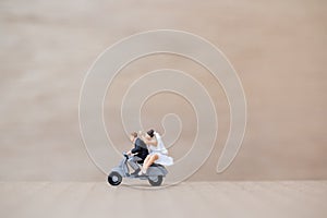 Miniature people : Bride and groom on wooden background with copy space for text