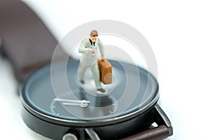 Miniature people : business man looking at watch and walk on the