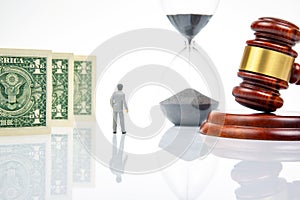 Miniature people. Business people stand near dollar money, hourglass and gavel for judgments. business concept