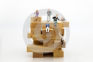 Miniature people: Business people sitting on puzzle pieces. Image use for find the answer of question, education , business