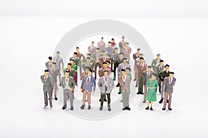 Miniature people business standing in crowd over white backdrop photo