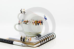 Miniature people : Business team sitting on book and having a coffee break. Image use for business concept